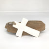 Pierre à parfumer en céramique artisanale Corse couleur blanche en forme de croix avec une ficelle, posé sur du bois à flotter.